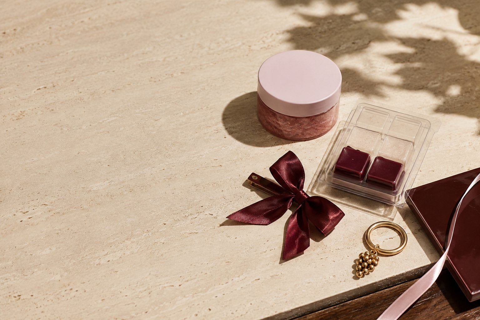 Sugar scrub, wax melts, a cabernet bow, and a gold grape keychain in a Napa craft studio still life